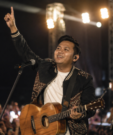 penyanyi membawakan musik daerah dengan gitar akustik