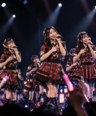 JKT48 saat tampil di atas panggung dengan formasi anggota yang membawakan pertunjukan penuh energi di hadapan para penggemar.