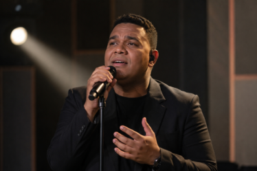 Andmesh Kamaleng tampil membawakan lagu di atas panggung konser dengan pencahayaan profesional.
