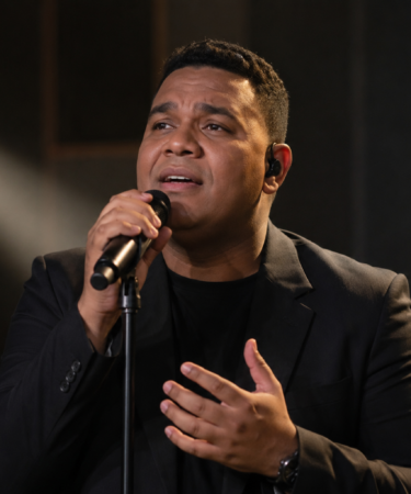 Andmesh Kamaleng tampil membawakan lagu di atas panggung konser dengan pencahayaan profesional.