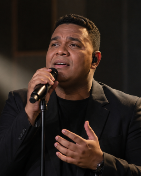 Andmesh Kamaleng tampil membawakan lagu di atas panggung konser dengan pencahayaan profesional.