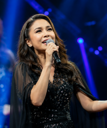 Rossa Penyanyi Indonesia tampil di atas panggung konser dengan pencahayaan megah dan ribuan penonton