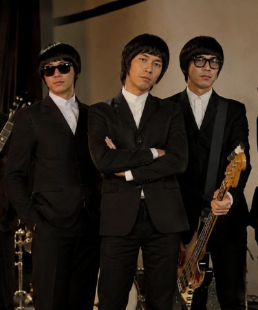 Personel The Changcuters tampil enerjik di atas panggung konser dengan nuansa rock and roll dan pencahayaan panggung yang meriah