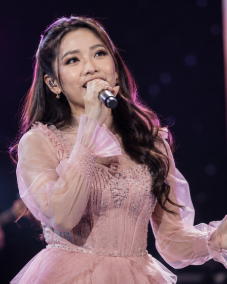 Tiara Andini tampil membawakan lagu di atas panggung konser dengan pencahayaan profesional dan penonton memenuhi area pertunjukan