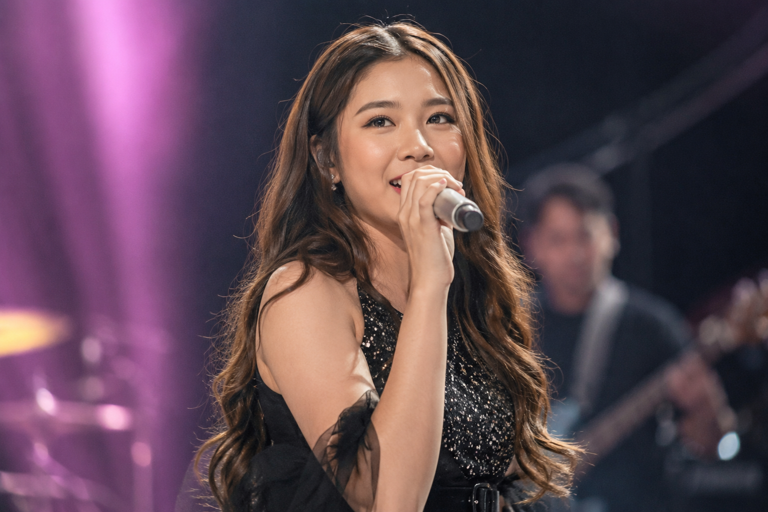 Tiara Andini tampil membawakan lagu di atas panggung konser dengan pencahayaan profesional.