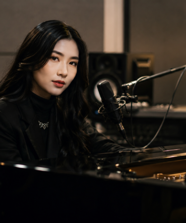 Isyana Sarasvati tampil di atas panggung membawakan karya musik dengan nuansa artistik dan pencahayaan konser yang dramatis