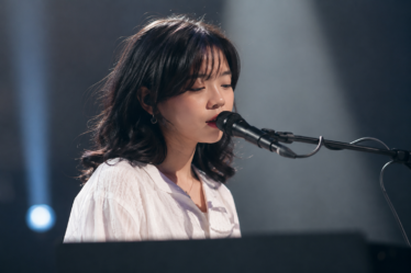 Feby Putri tampil membawakan lagu dengan gitar akustik di atas panggung konser, menggambarkan karakter musik folk-pop yang khas.