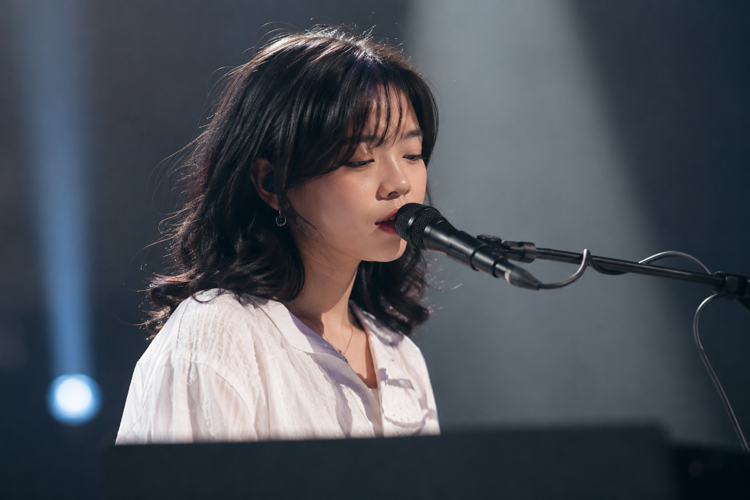 Feby Putri tampil membawakan lagu dengan gitar akustik di atas panggung konser, menggambarkan karakter musik folk-pop yang khas.