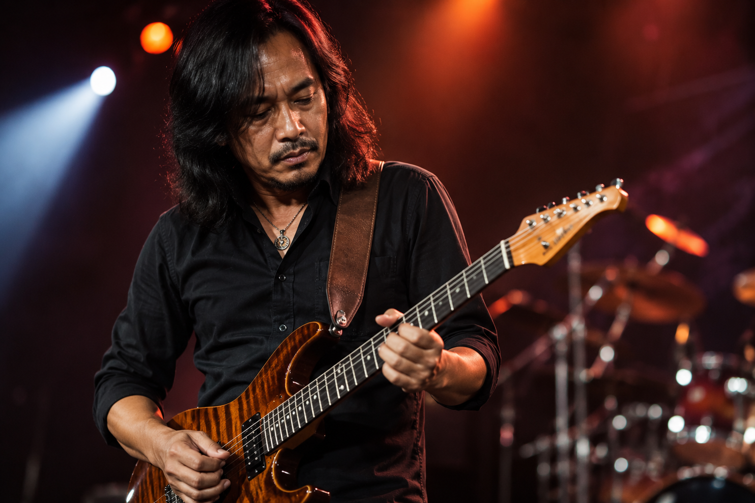 Dewa Budjana memainkan gitar elektrik saat tampil di atas panggung konser musik