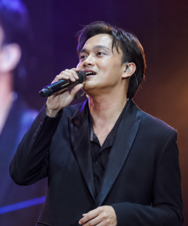 Rizky Febian tampil membawakan lagu di atas panggung konser dengan penampilan profesional sebagai penyanyi pop Indonesia.