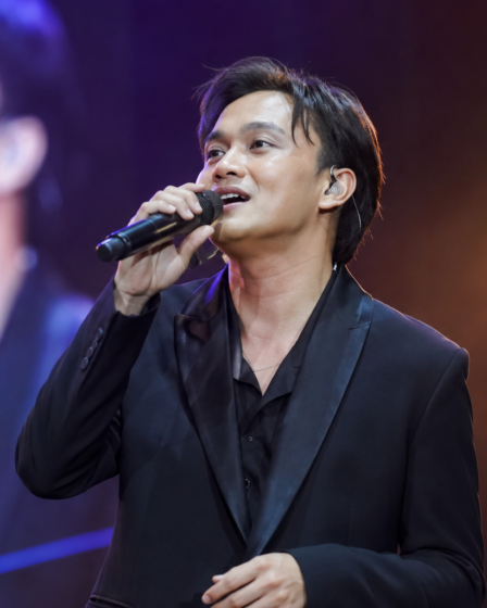 Rizky Febian tampil membawakan lagu di atas panggung konser dengan penampilan profesional sebagai penyanyi pop Indonesia.