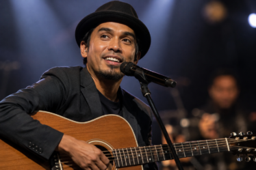Glenn Fredly tampil membawakan lagu di atas panggung konser sebagai salah satu musisi Indonesia yang menginspirasi industri musik.