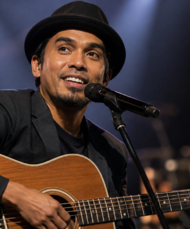 Glenn Fredly tampil membawakan lagu di atas panggung konser sebagai salah satu musisi Indonesia yang menginspirasi industri musik.