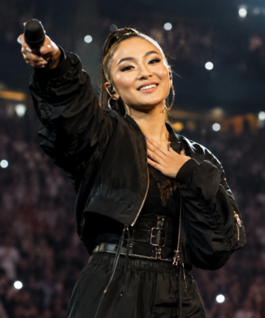 Agnez Mo tampil di atas panggung konser internasional dengan tata cahaya megah dan penampilan energik