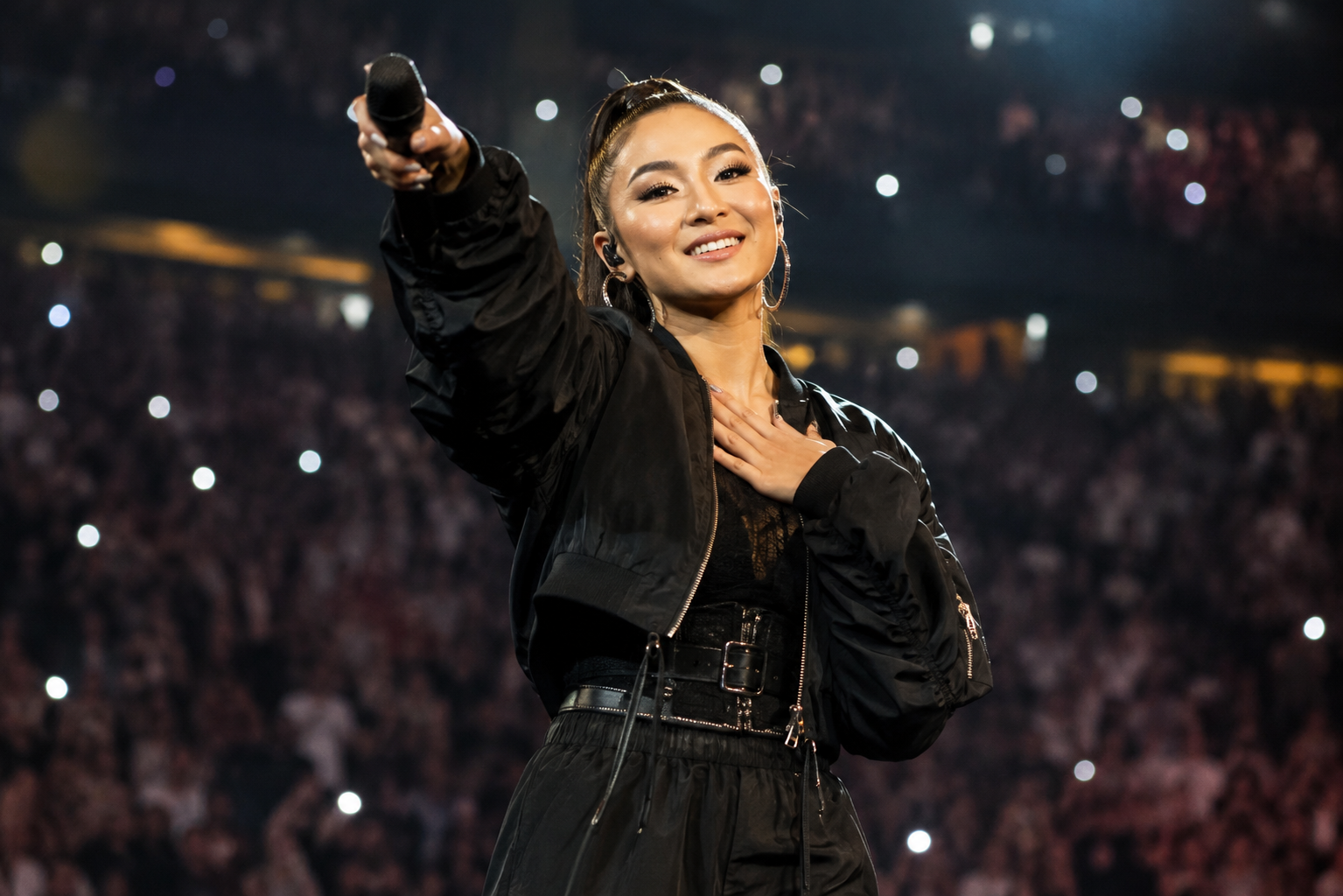 Agnez Mo tampil di atas panggung konser internasional dengan tata cahaya megah dan penampilan energik
