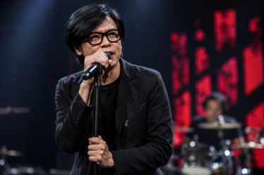 Armand Maulana tampil membawakan lagu bersama band GIGI di atas panggung konser.