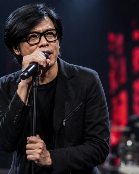 Armand Maulana tampil membawakan lagu bersama band GIGI di atas panggung konser.