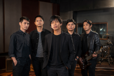 Personel D'Masiv tampil membawakan lagu di atas panggung konser dengan pencahayaan profesional dan suasana meriah