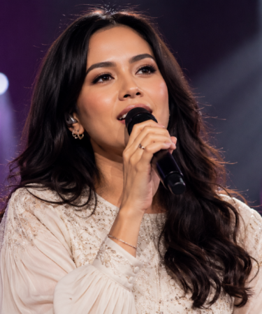 Raisa tampil di atas panggung konser membawakan lagu dengan penuh penghayatan di hadapan ribuan penonton.