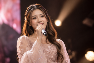 Tiara Andini tampil membawakan lagu di atas panggung konser dengan ekspresi penuh percaya diri dan karakter vokal yang khas.