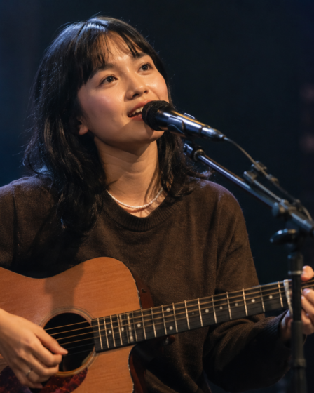 Idgitaf tampil membawakan lagu di atas panggung dengan pencahayaan hangat dan suasana intim