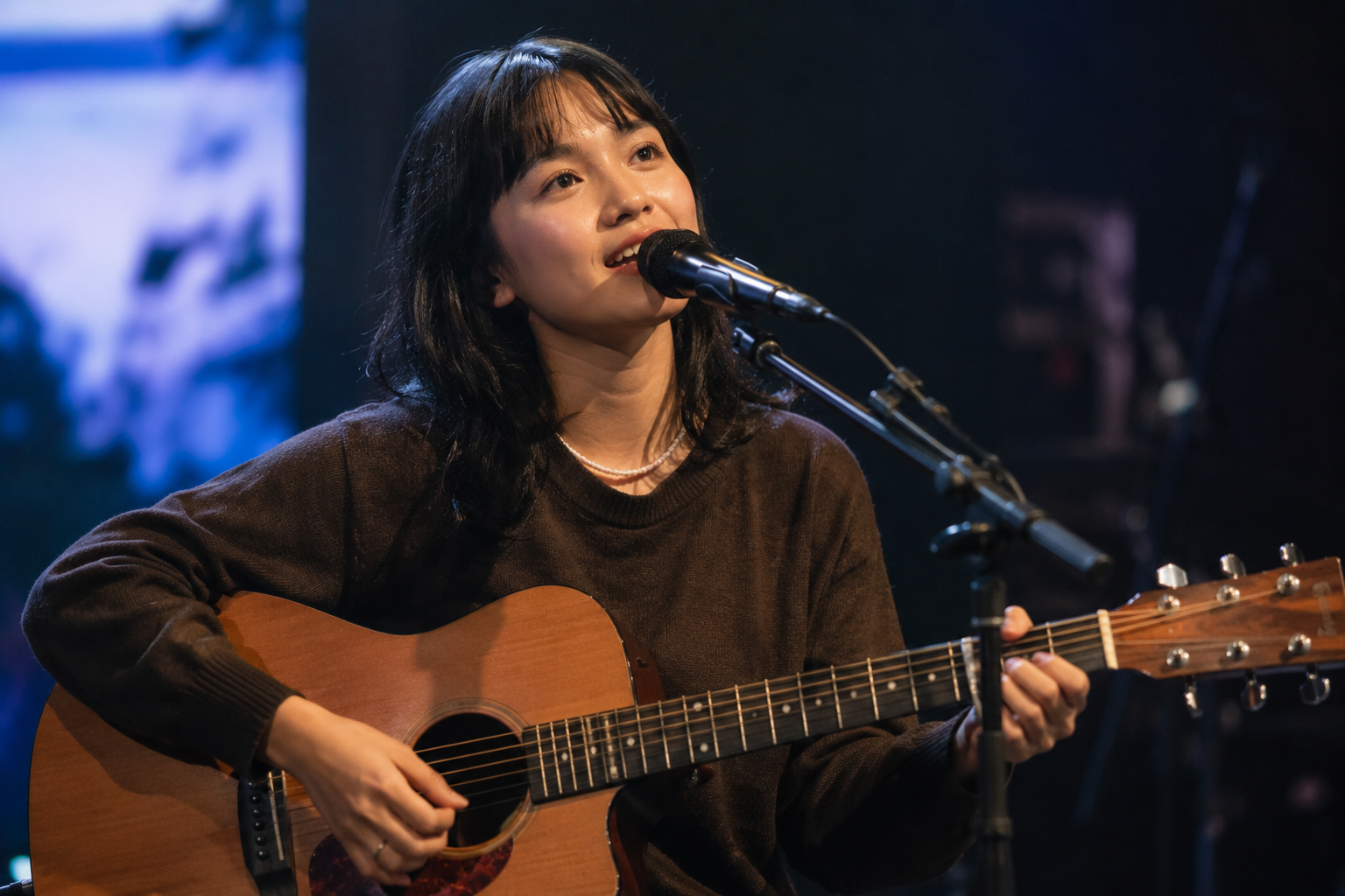 Idgitaf tampil membawakan lagu di atas panggung dengan pencahayaan hangat dan suasana intim