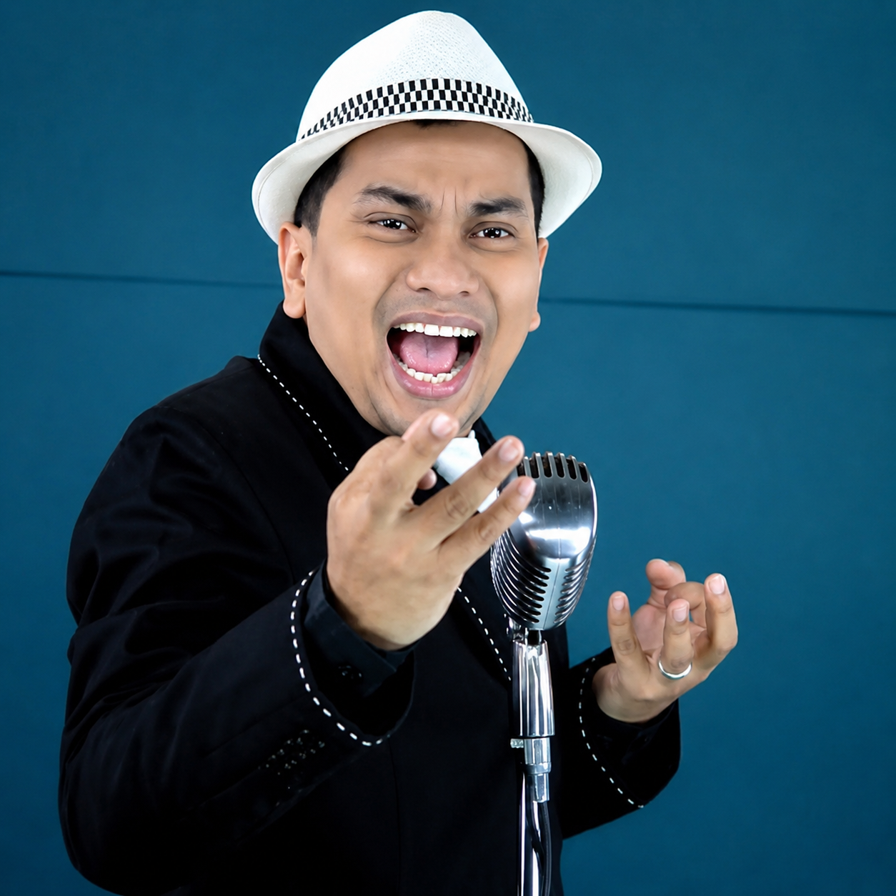 Tompi tampil di atas panggung membawakan lagu jazz dengan iringan band dan pencahayaan konser profesional.