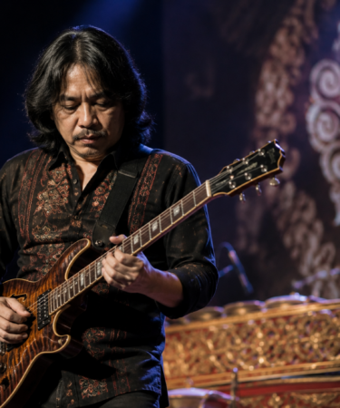 Dewa Budjana memainkan gitar elektrik saat tampil di atas panggung konser musik jazz.