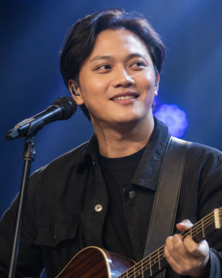 Rizky Febian tampil membawakan lagu di atas panggung konser dengan pencahayaan profesional dan penampilan yang khas.