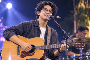 Budi Doremi tampil membawakan lagu di atas panggung konser dengan pencahayaan profesional dan penonton yang antusias