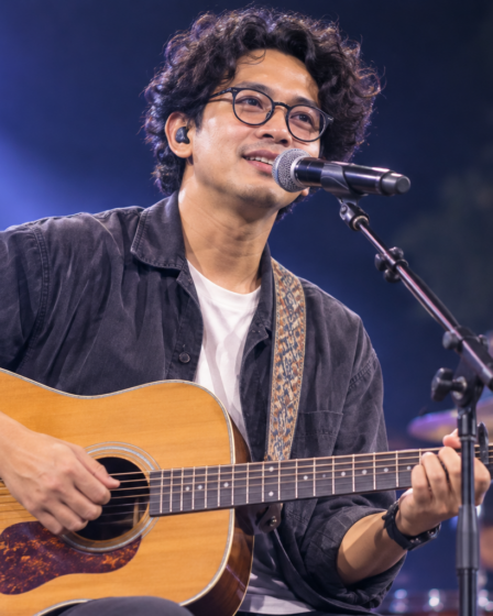Budi Doremi tampil membawakan lagu di atas panggung konser dengan pencahayaan profesional dan penonton yang antusias